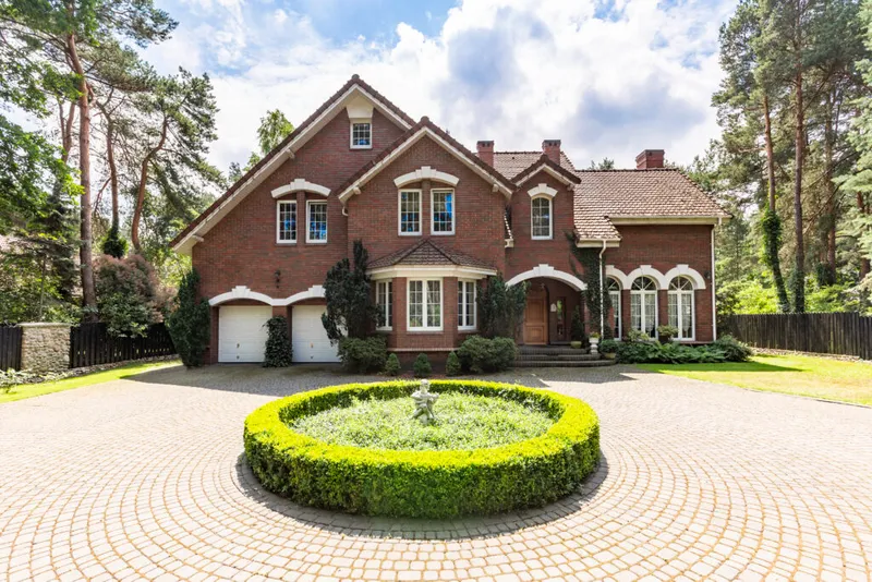 A house with a circular driveway and landscaped garden